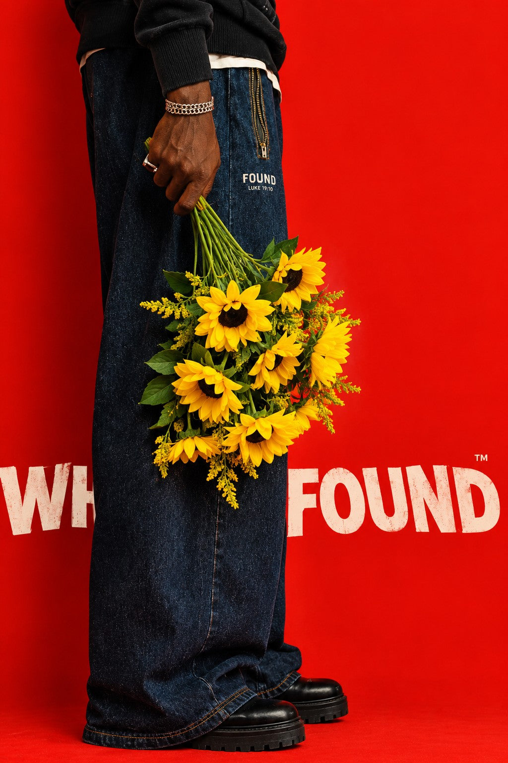 Sunflowers held against a red backdrop, FOUND Luke 19:10 printed on the jeans